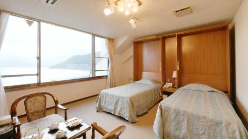 a hotel room with two beds and a window at Hotel Koryu in Fujikawaguchiko