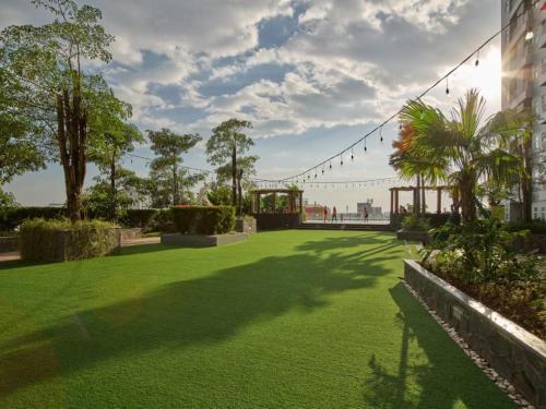 a green lawn with a string of lights in a park at TripleQ Room 2BR Vidaview Apartment in Makassar