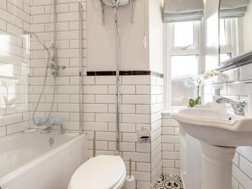 a white bathroom with a toilet and a sink at West House in Wooler