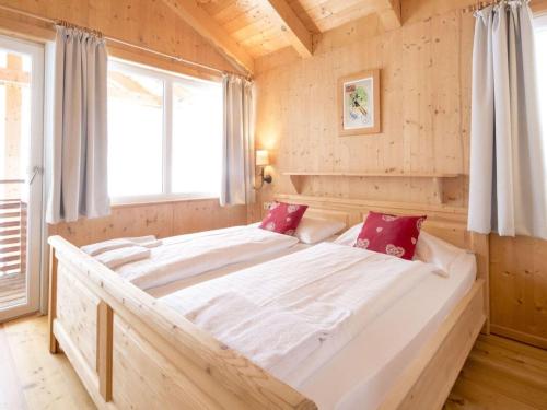 a large white bed in a room with a window at Chalet Alpenpark Turracherhöhe 2 in Turracher Hohe