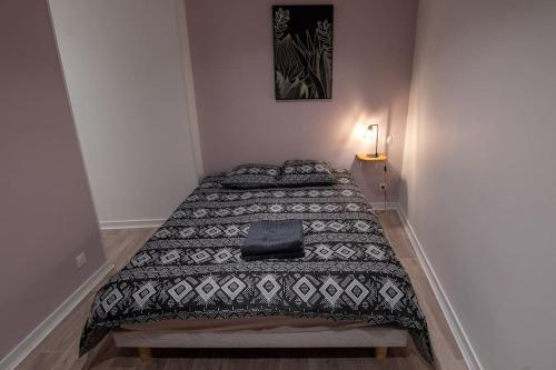 - une chambre avec un lit et une couverture dans l'établissement Appartement Quai Jean Jaurès Le Panorama, à Mâcon