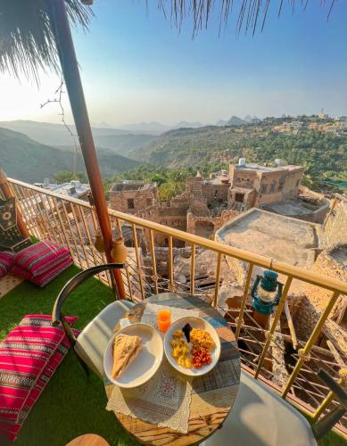 a table with a plate of food on a balcony at Al Misfah Hospitality Inn in Misfāh