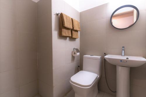 a bathroom with a toilet and a sink and a mirror at Modern Condo with pool and gym in Cagayan de Oro