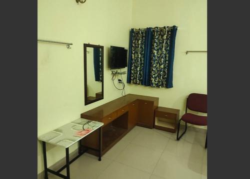 a room with a desk and a mirror and a chair at Geetha Residency in Kanchipuram
