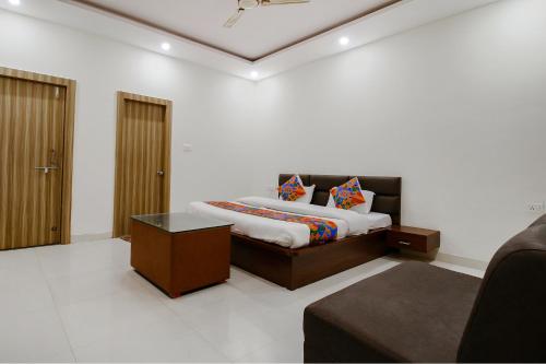 a bedroom with a bed and a couch in it at FabExpress Yuvan in Naiāpura