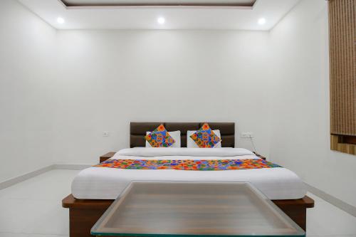 a bedroom with a large bed with white sheets at FabExpress Yuvan in Naiāpura