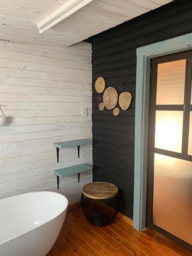 a bathroom with a tub and a toilet and a table at Cabins Sodwana Bay - antibootika in Sodwana Bay
