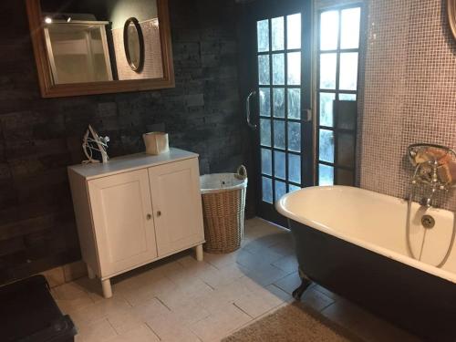 une salle de bain avec une baignoire, un lavabo et un miroir dans l'établissement Propriété, lac, plages privées IDF 77 proche Paris, à La Tombe