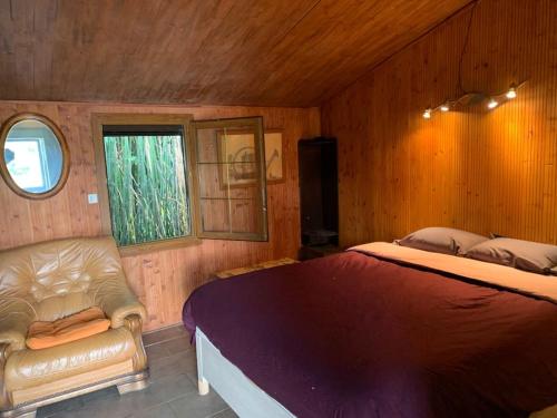 une chambre avec un lit, un canapé et une fenêtre dans l'établissement Propriété, lac, plages privées IDF 77 proche Paris, à La Tombe