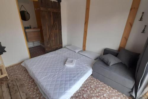 um pequeno quarto com uma cama e um sofá em Nada vineyard em Rakhat