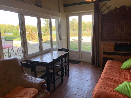 un salon avec une table et un canapé dans l'établissement Propriété, lac, plages privées IDF 77 proche Paris, à La Tombe