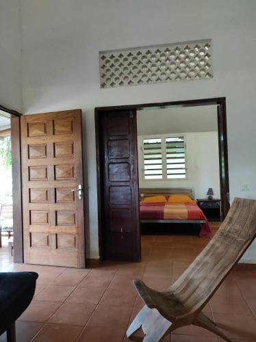 a bedroom with a bed and a door with a mirror at Tikoté Chwit point 1 in Cayenne