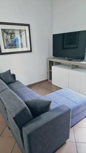 a living room with a blue couch and a tv at Loft Garibaldi in Correggio