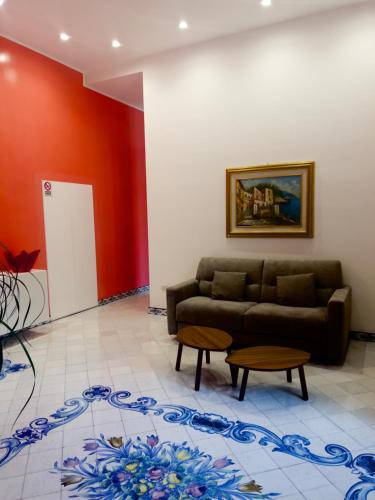 a living room with a couch and a red wall at Hotel Ausonia in Naples