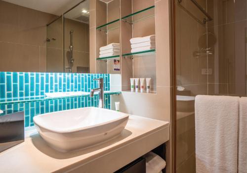 a bathroom with a sink and a shower at Radisson Resort and Suites Phuket in Kamala Beach