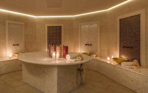 uma grande casa de banho com uma grande banheira em mármore com velas em Talaria Resort&Spa em Trojanów