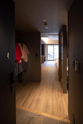 a hallway with a door open to a room with wood floors at Minakami Onsen Aratashi Minakami in Minakami
