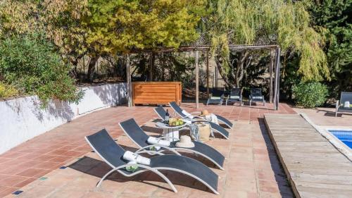 a patio with chairs and a table and a pool at Arroyo del Moro Gaucín by Ruralidays in Gaucín