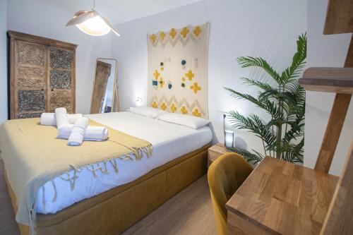 a bedroom with a bed and a table and a plant at Apartamento La Habanera de Cadiz in Cádiz