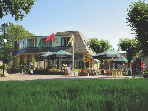 a building with a flag and tables and chairs at Hotel Kuik in Ruinen