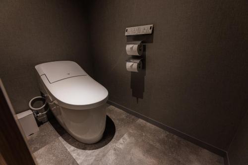 a bathroom with a white toilet in a stall at Minakami Onsen Aratashi Minakami in Minakami