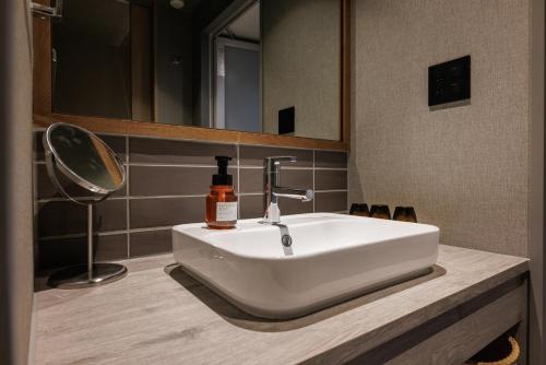 a white sink in a bathroom with a mirror at Minakami Onsen Aratashi Minakami in Minakami