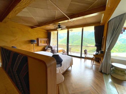 a bedroom with a bed and a large window at Le Champ Tu Le Resort Hot Spring & Spa in Yen Bai
