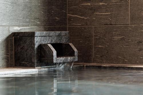a fountain in a building with water coming out of it at Minakami Onsen Aratashi Minakami in Minakami