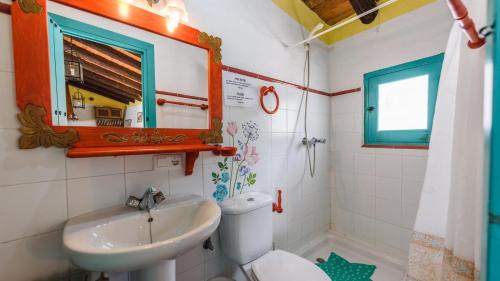 a bathroom with a sink and a toilet and a mirror at El Acebuchal - Casa Rosa Frigiliana by Ruralidays in Frigiliana