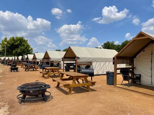 a row of tents with picnic tables and a grill at Son's Rio Cibolo - Glamping Cabin #J Romantic Getaway on Gorgeous Cibolo Creek! in Marion