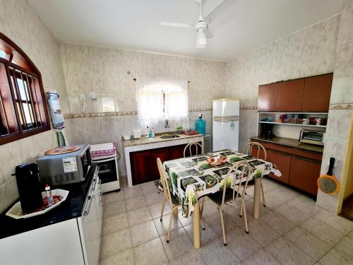 uma cozinha com uma mesa com cadeiras e um frigorífico em Casa em Condomínio com Piscina Privativa em Araruama