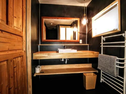 a bathroom with a sink and a mirror at Fujio Pension Madarao Apartment Hotel & Restaurant in Iiyama