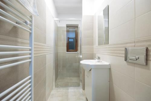 a white bathroom with a sink and a shower at Vila Stadion in Câmpulung Moldovenesc