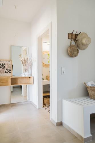 a white hallway with a bench and a mirror at Magnolia Villas Thassos in Potos