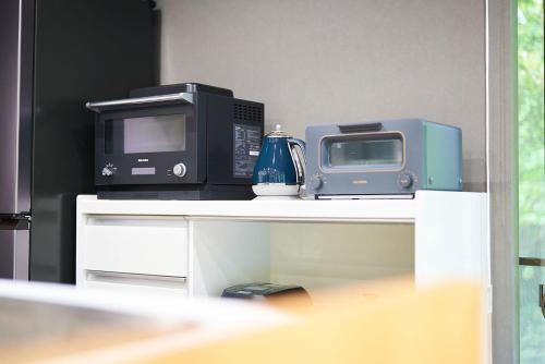 a microwave and a toaster oven on a table at Asagiri hideaway FUJI-朝霧 富士の隠れ宿- in Fujinomiya