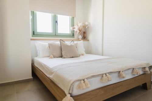 a white bedroom with a large bed with white pillows at Magnolia Villas Thassos in Potos