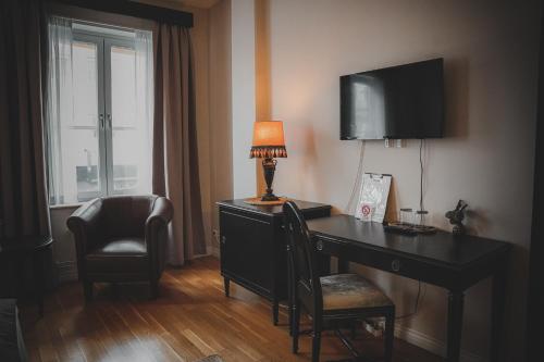 um quarto com uma secretária com um candeeiro e uma cadeira em Mojo Hotell em Örebro