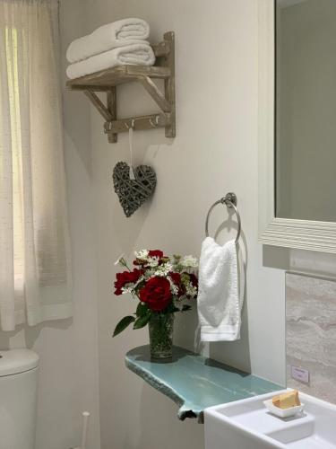 La salle de bains est pourvue d'un vase de fleurs et de serviettes. dans l'établissement Cedarview Bed & Breakfast, à Beechmont