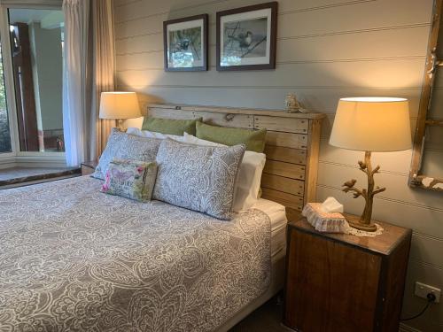 a bedroom with a bed and a table with a lamp at Cedarview Bed & Breakfast in Beechmont