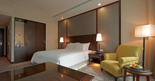 a hotel room with a bed and a chair at Eastin Hotel Kuala Lumpur in Petaling Jaya