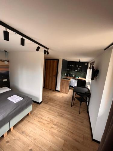 a bedroom with a bed and a dining room at Apartamenty i Chata Drewno i Kamień in Wetlina