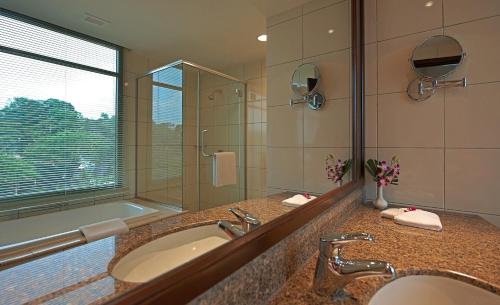 a bathroom with a sink and a shower and a tub at Eastin Hotel Kuala Lumpur in Petaling Jaya