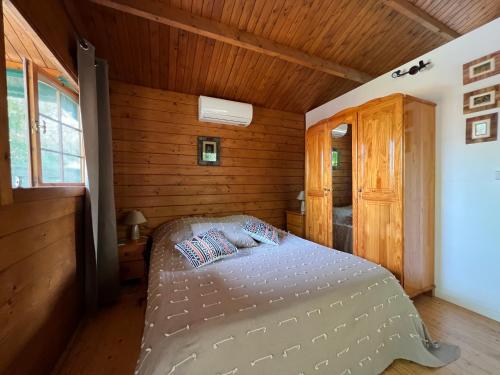 una camera con un letto in una cabina di legno di L'Ilot Zoizeaux a Les Avirons