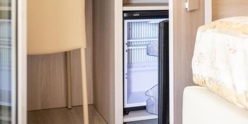 ajar view of an empty refrigerator in a room at Hotel Angelo in Caorle