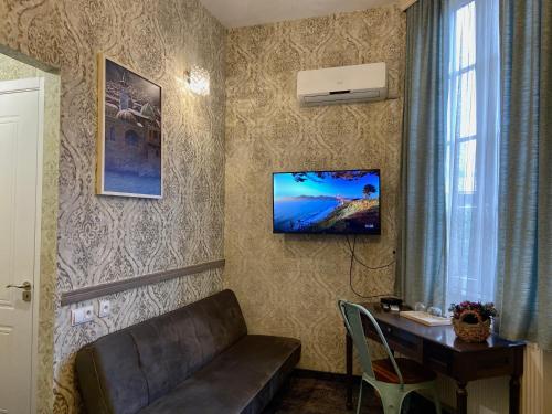 a living room with a couch and a desk in a room at Boutique Hotel Alegria in Tbilisi City