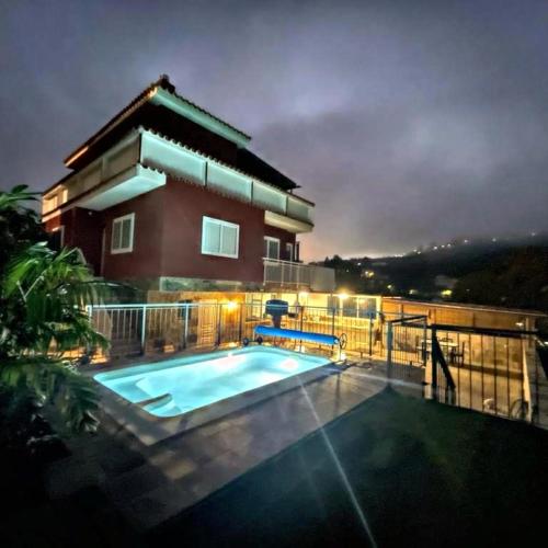 a house with a swimming pool at night at Villa Aguacate in Teror