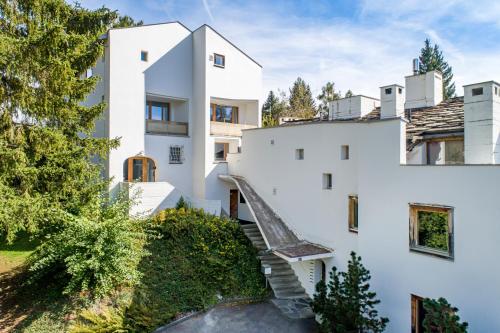 a white house with a staircase in front of it at Casa Las Caglias in Flims