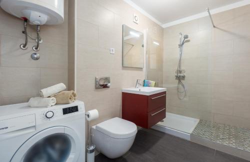 een badkamer met een toilet, een wastafel en een wasmachine bij Apartment Mara Premium in Poreč
