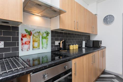 a kitchen with wooden cabinets and a black counter top at The Station House in Preston