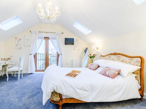 a bedroom with a large white bed with a chandelier at Hayloft- Uk31532 in Goxhill